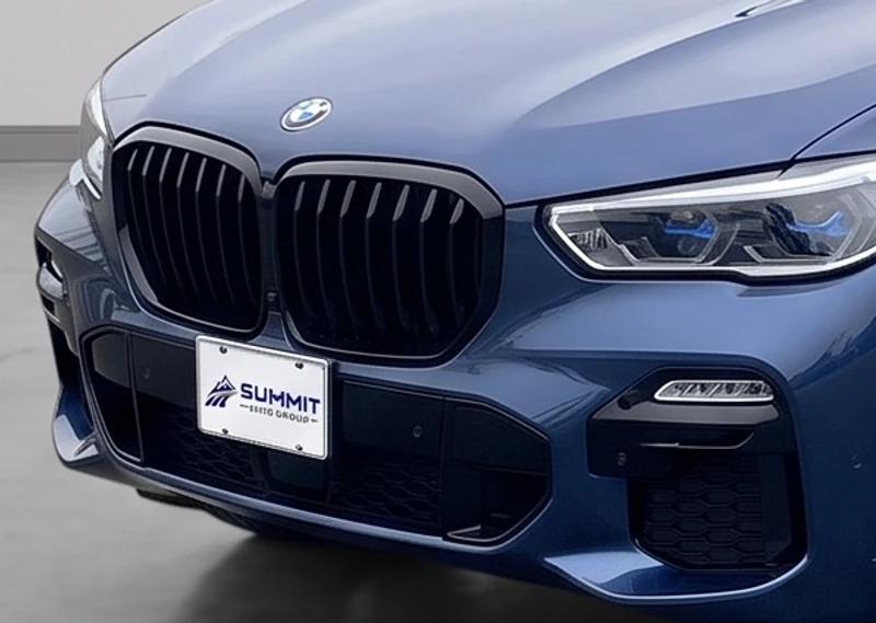 Close-up of a BMW with a Summit Auto Group branded license plate