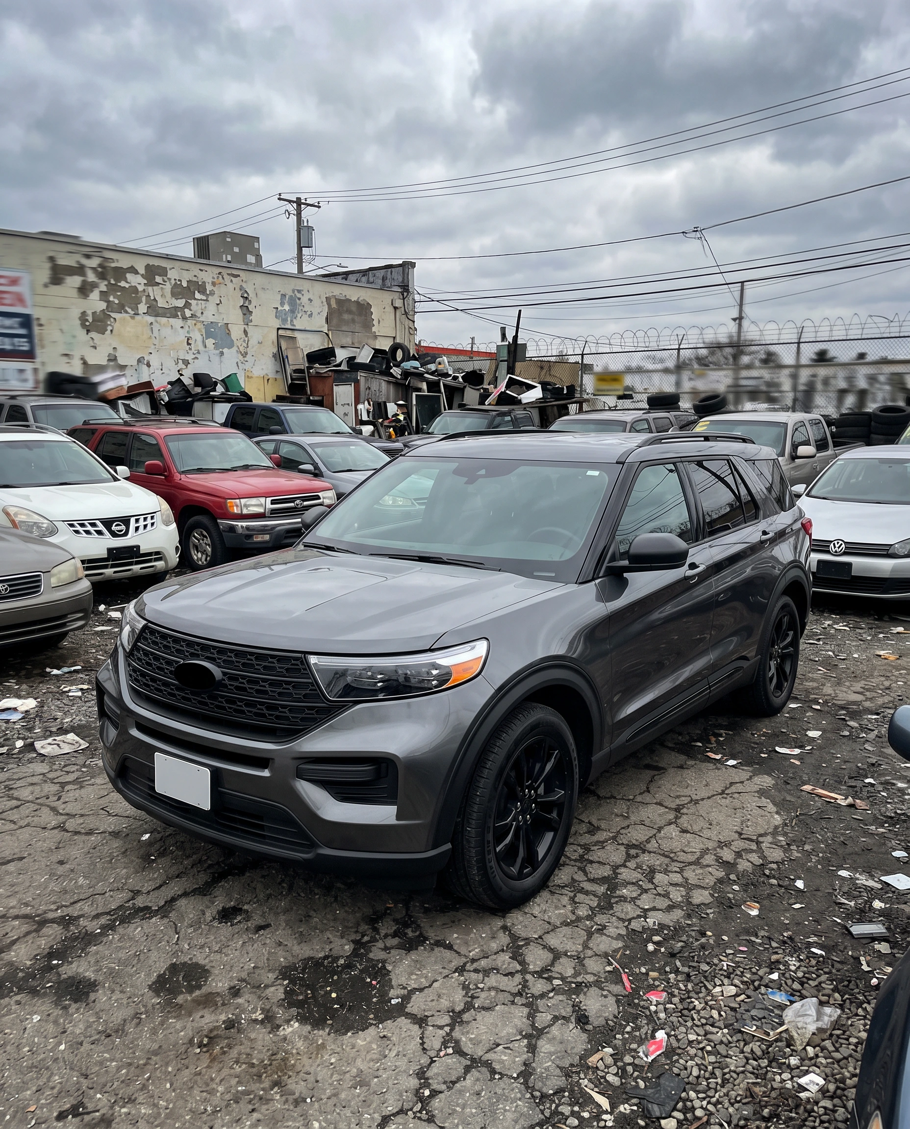 Ford Explorer inventory photo on a cluttered used car lot before CarPixAI background replacement